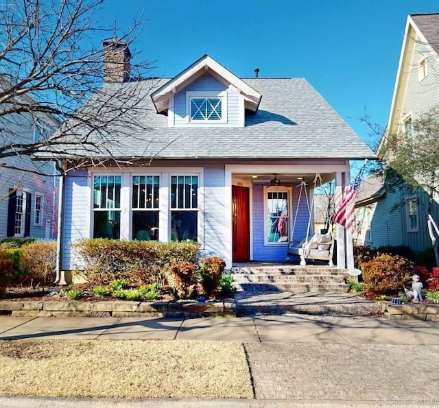 bungalow-style home with a shingled roof and a chimney