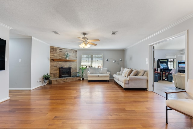 unfurnished living room featuring light wood finished floors, crown molding, visible vents, and a textured ceiling