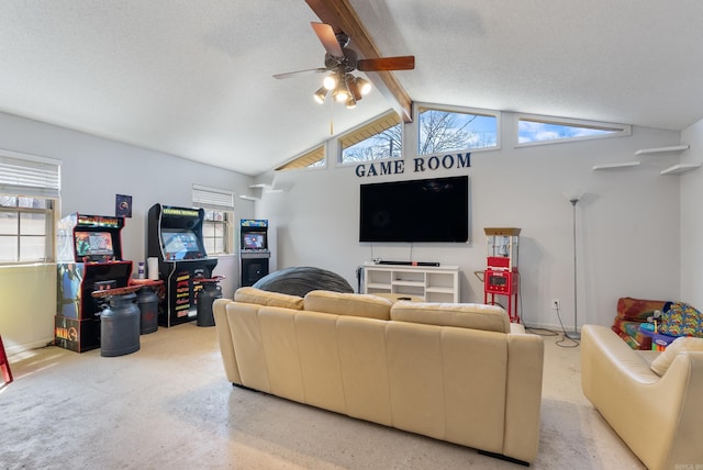 living area with a ceiling fan, a healthy amount of sunlight, vaulted ceiling with beams, and a textured ceiling