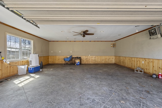 garage with a wainscoted wall, a ceiling fan, and wooden walls