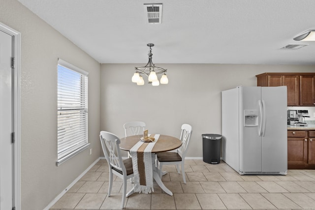 dining room with visible vents, a notable chandelier, baseboards, and light tile patterned floors