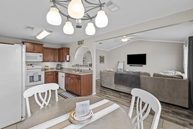 kitchen with lofted ceiling, white appliances, visible vents, and open floor plan