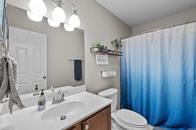 bathroom featuring a notable chandelier, curtained shower, a textured wall, toilet, and vanity