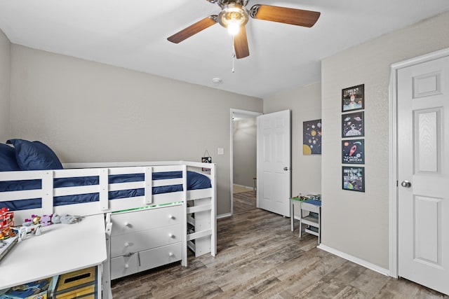 bedroom featuring wood finished floors, a ceiling fan, and baseboards