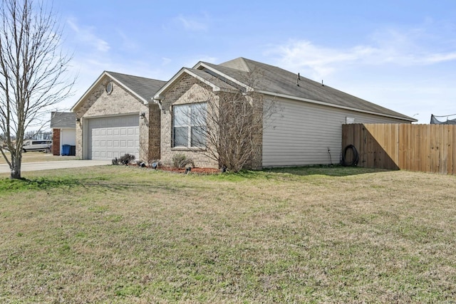 exterior space with brick siding, concrete driveway, a front yard, fence, and a garage