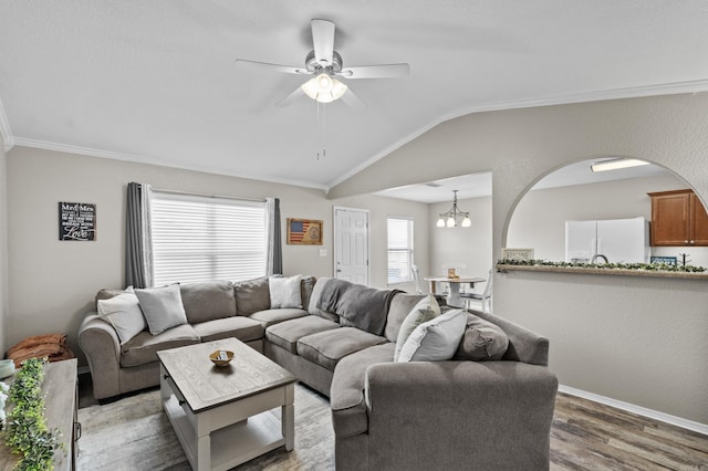 living room with vaulted ceiling, ceiling fan, wood finished floors, and crown molding