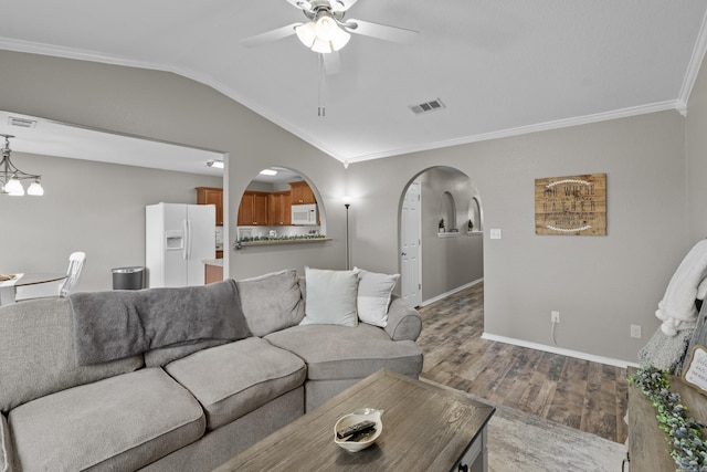 living area featuring arched walkways, lofted ceiling, visible vents, ornamental molding, and wood finished floors