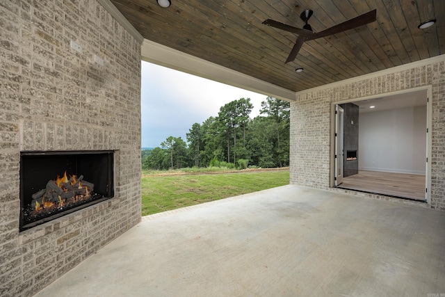 view of patio / terrace featuring an outdoor brick fireplace and a ceiling fan