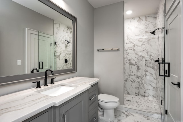 bathroom with toilet, marble finish floor, a marble finish shower, and vanity