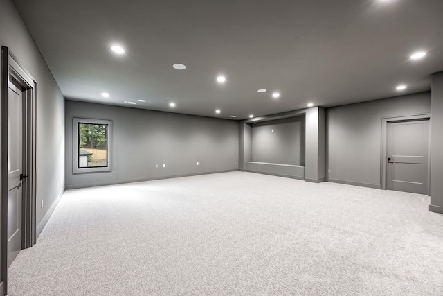 spare room with recessed lighting, light colored carpet, and baseboards