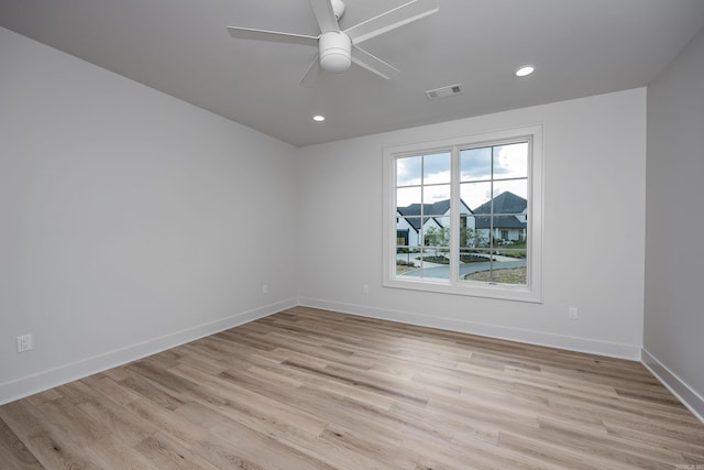 empty room with light wood-style floors, recessed lighting, visible vents, and baseboards