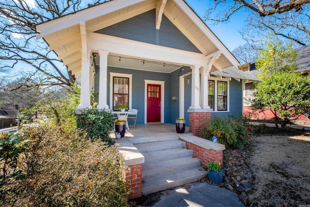 property entrance with covered porch and brick siding