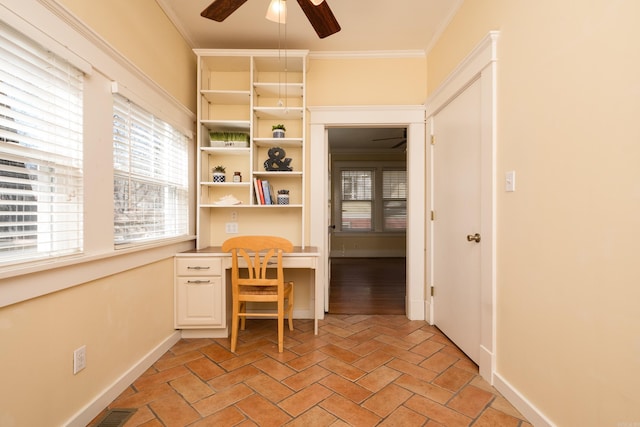 office area featuring baseboards, a ceiling fan, crown molding, and built in study area