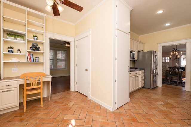 kitchen featuring appliances with stainless steel finishes, ornamental molding, ceiling fan with notable chandelier, built in desk, and recessed lighting