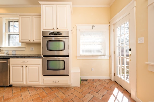 kitchen featuring ornamental molding, tile countertops, appliances with stainless steel finishes, and baseboards