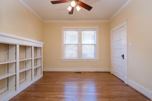 unfurnished room with crown molding, baseboards, and wood finished floors