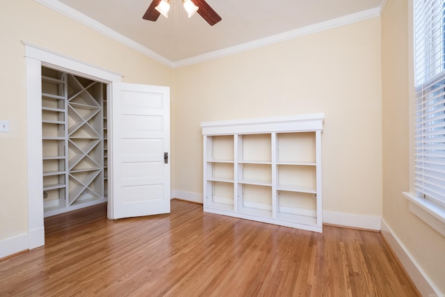 unfurnished bedroom featuring ornamental molding, a ceiling fan, light wood-style flooring, and baseboards