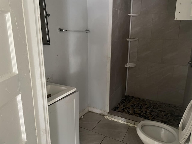 bathroom featuring a stall shower, tile patterned flooring, vanity, and toilet