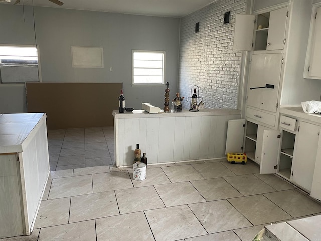 3204 S Linden St, Pine Bluff, AR 71603 - kitchen with tile countertops, light tile patterned floors, ceiling fan, brick wall, and open shelves