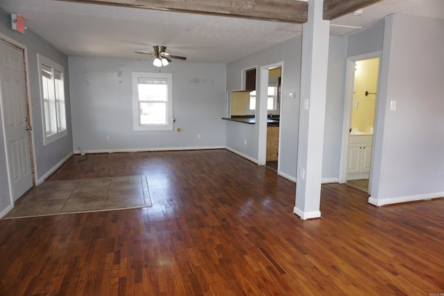 unfurnished living room featuring ceiling fan, baseboards, and dark wood-style flooring