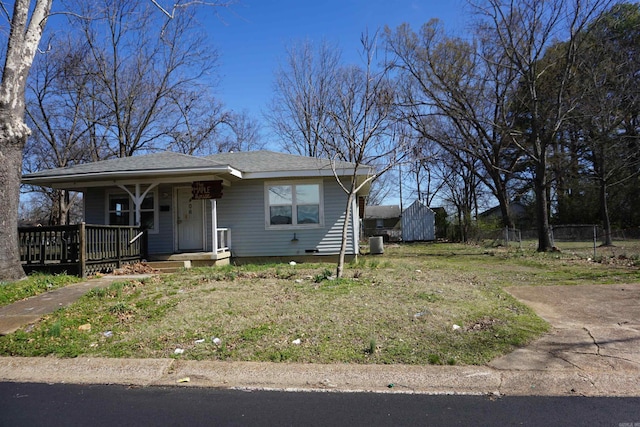 bungalow with a storage shed, an outbuilding, fence, central air condition unit, and a porch