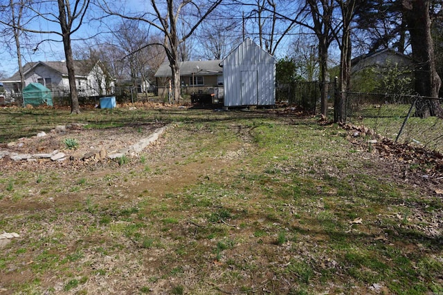 view of yard featuring fence, an outdoor structure, and a storage unit