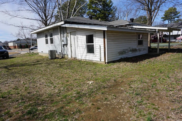 exterior space with central AC unit and a lawn