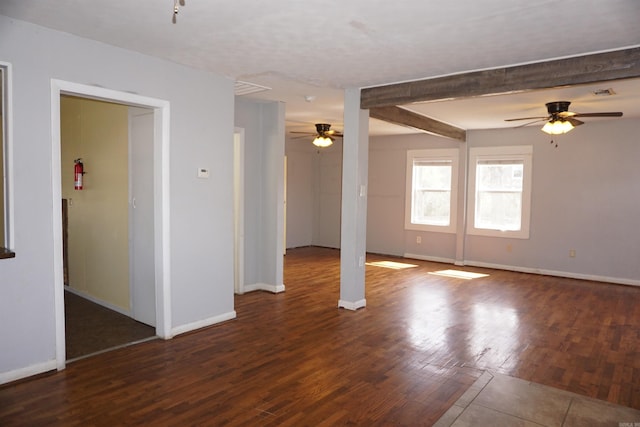 unfurnished room with a ceiling fan, beam ceiling, baseboards, and wood finished floors