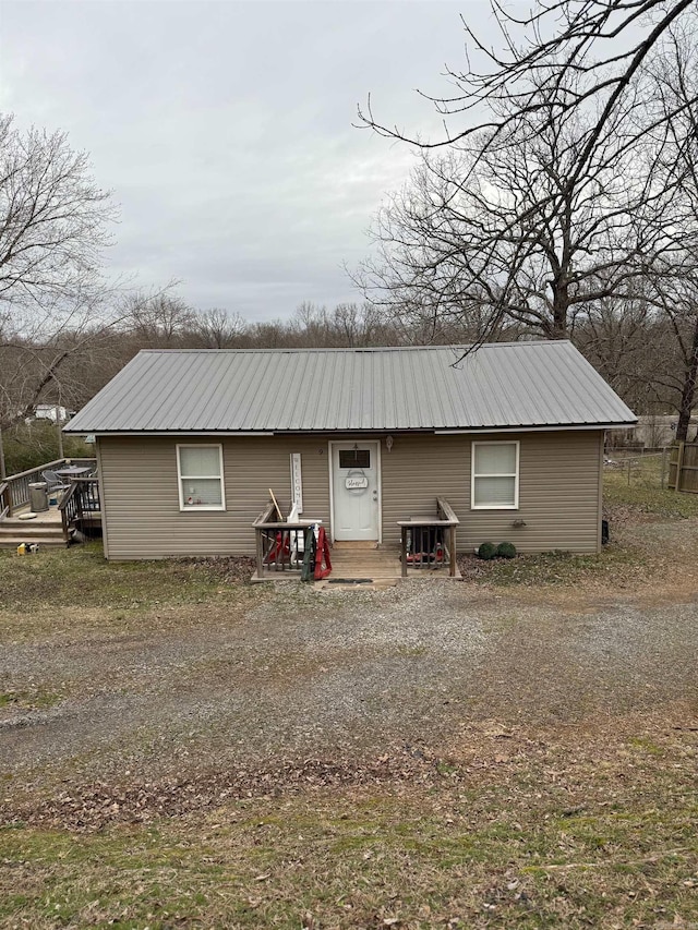 back of house with entry steps, metal roof, and a deck