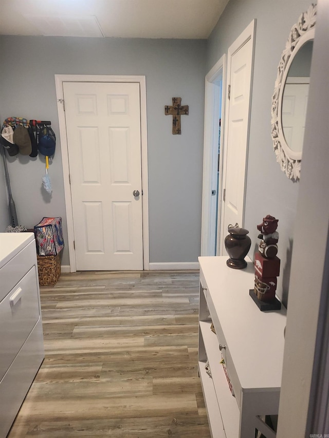 interior space featuring baseboards, washer / dryer, and light wood-style floors