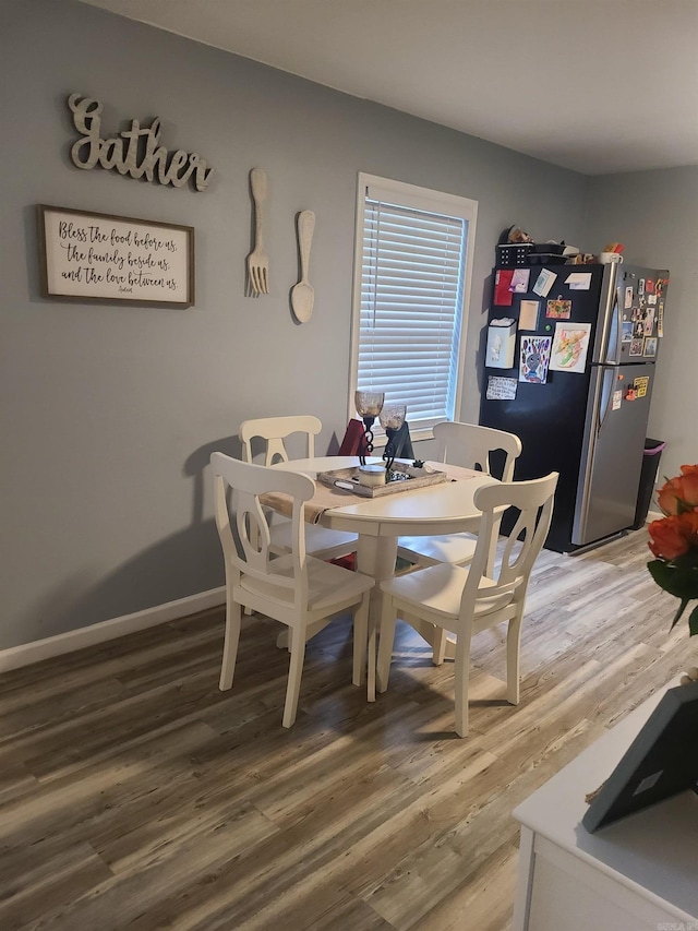 dining room featuring light wood finished floors and baseboards