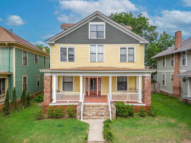 traditional style home with covered porch and a front lawn