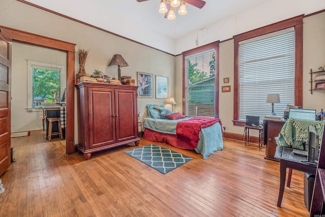 bedroom with light wood-style floors, baseboards, and a ceiling fan