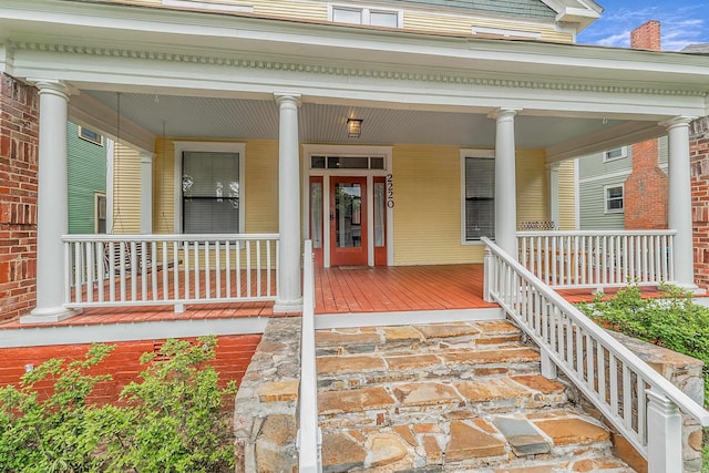 property entrance with covered porch and brick siding