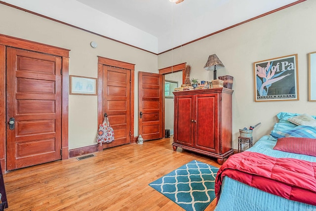 bedroom with light wood-style floors, visible vents, and baseboards