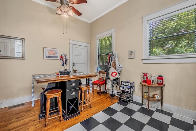 interior space featuring ceiling fan, visible vents, baseboards, tile patterned floors, and crown molding