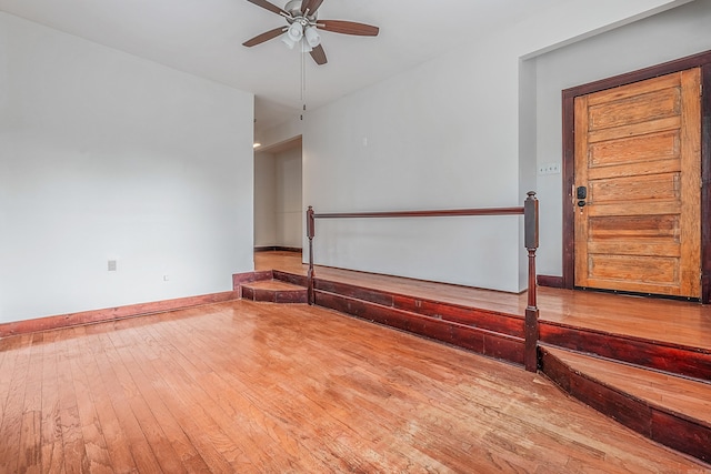 unfurnished room with ceiling fan, baseboards, and hardwood / wood-style flooring