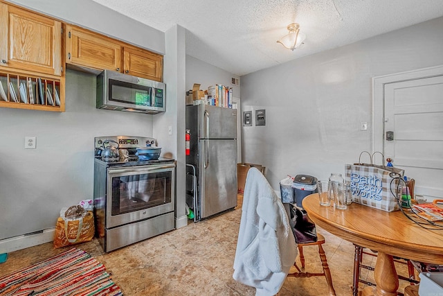 kitchen featuring appliances with stainless steel finishes, visible vents, a textured ceiling, and baseboard heating