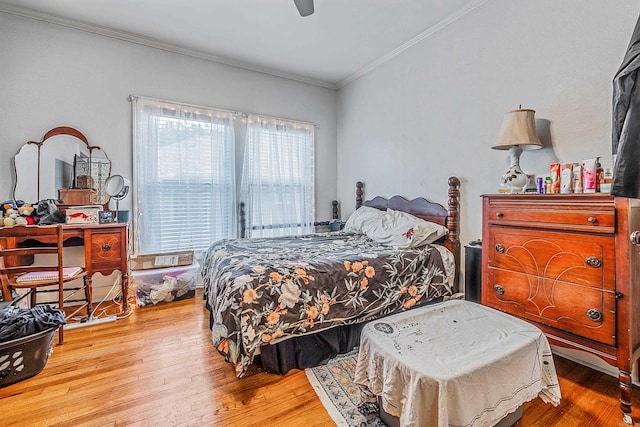 bedroom with crown molding, ceiling fan, and wood finished floors