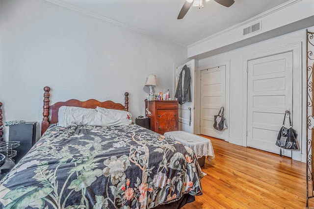 bedroom featuring light wood-style flooring, visible vents, a ceiling fan, and ornamental molding