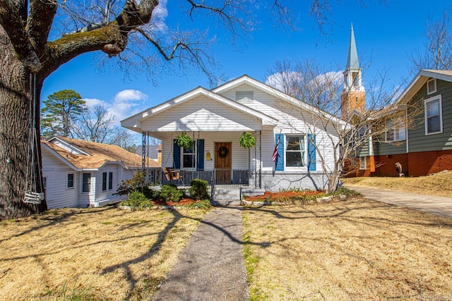 bungalow-style house featuring a front yard and covered porch