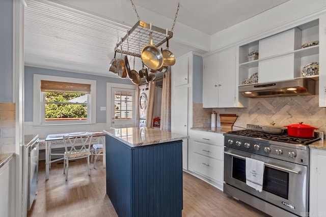 kitchen with high end stainless steel range oven, white cabinets, light wood-style floors, and a center island