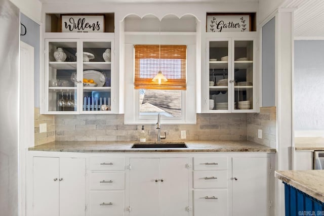 bar featuring tasteful backsplash and a sink