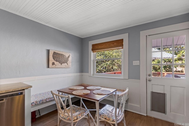 dining room featuring breakfast area, wooden ceiling, wainscoting, and wood finished floors