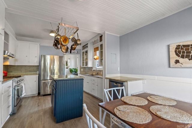 kitchen with light wood finished floors, appliances with stainless steel finishes, a center island, and white cabinets