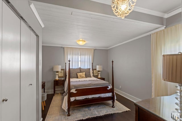 bedroom with crown molding, a closet, dark wood-type flooring, a chandelier, and baseboards