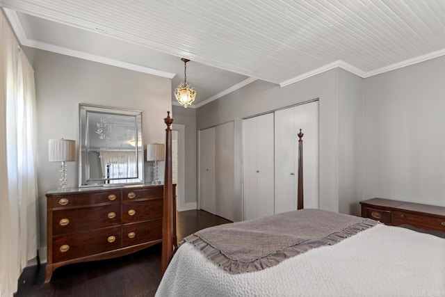 bedroom with dark wood-style floors, crown molding, and two closets