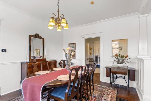 dining room with ornate columns, ornamental molding, and wood finished floors