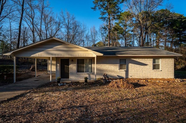 view of front of home featuring a carport, brick siding, and concrete driveway