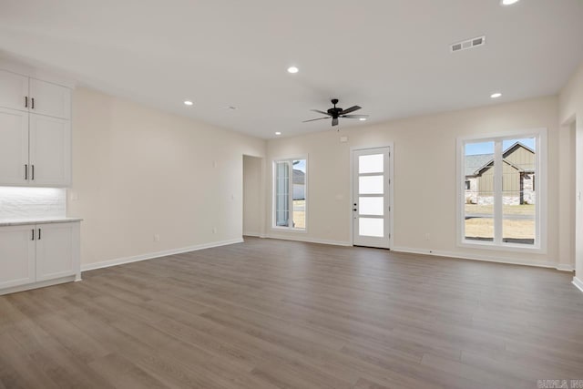 unfurnished living room with light wood finished floors, recessed lighting, visible vents, and a healthy amount of sunlight